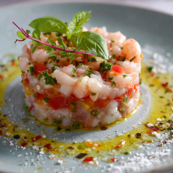 Una fetta di pesce con erbe e peperoncini.