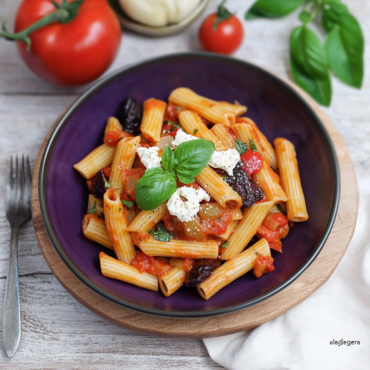 Una tavolata con un piatto di pasta e verdure.