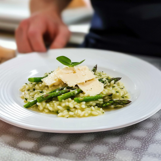 Una tavolata con un piatto di pasta e asparagi.