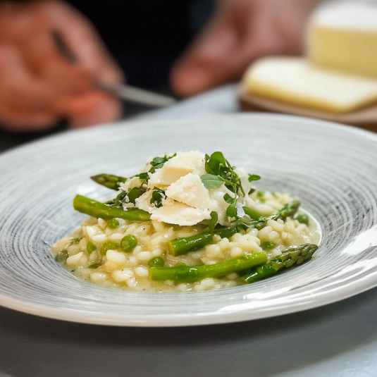 Una tavolata con un piatto di pasta e verdura.