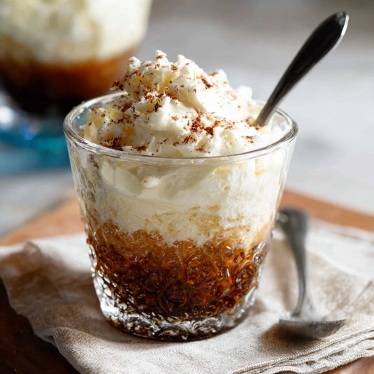 Un bicchiere di crema con cacao e cannoli.