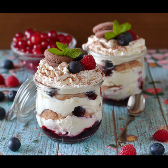 Due vasi con frullati di frutta e crema.