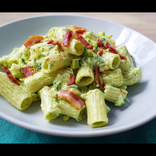 Piatti di pasta con bacon e verdure.