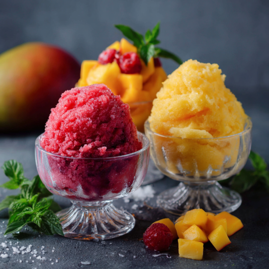 Due bicchieri di gelato con frutta.
