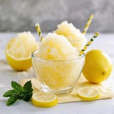 Una tazza di neve con un limone accanto.