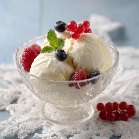 Un bicchiere con del gelato e frutta.