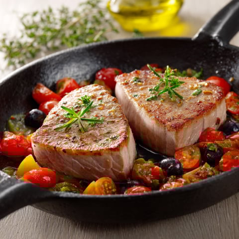 Due filetti di pesce con erbe fresche.