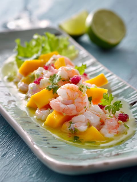 Una tavolata con frullati di frutta e pesce.