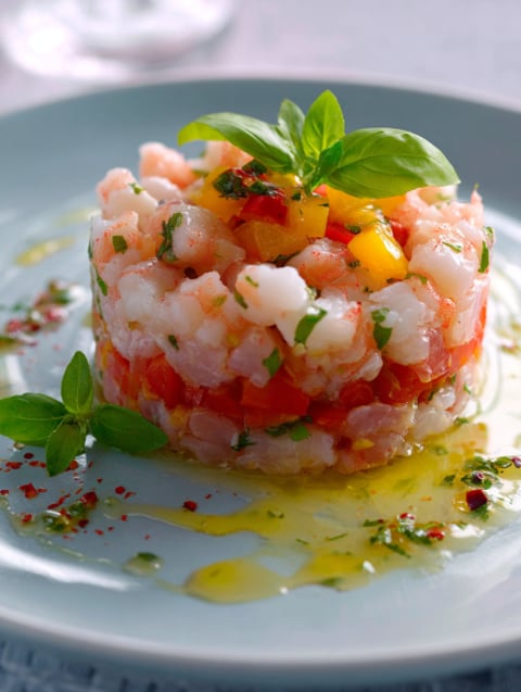 Una tazza di pesce con erbe e olio.