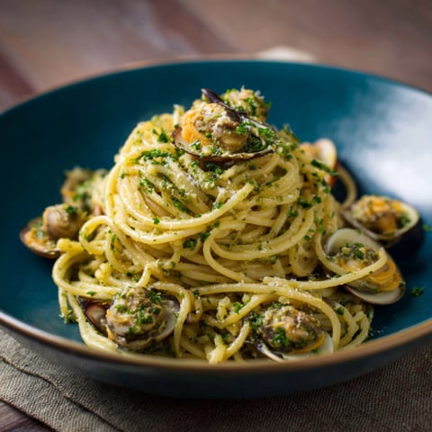 Un piatto di spaghetti con ostriche e verdure.