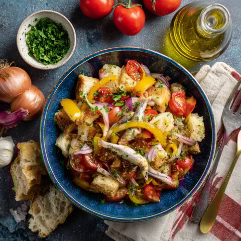 Una tavolata con un piatto di verdure e pomodori.