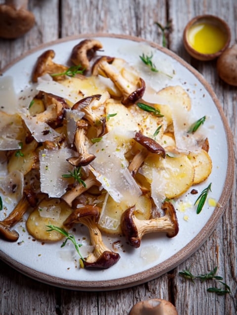 Un piatto di funghi con erbe e formaggio.